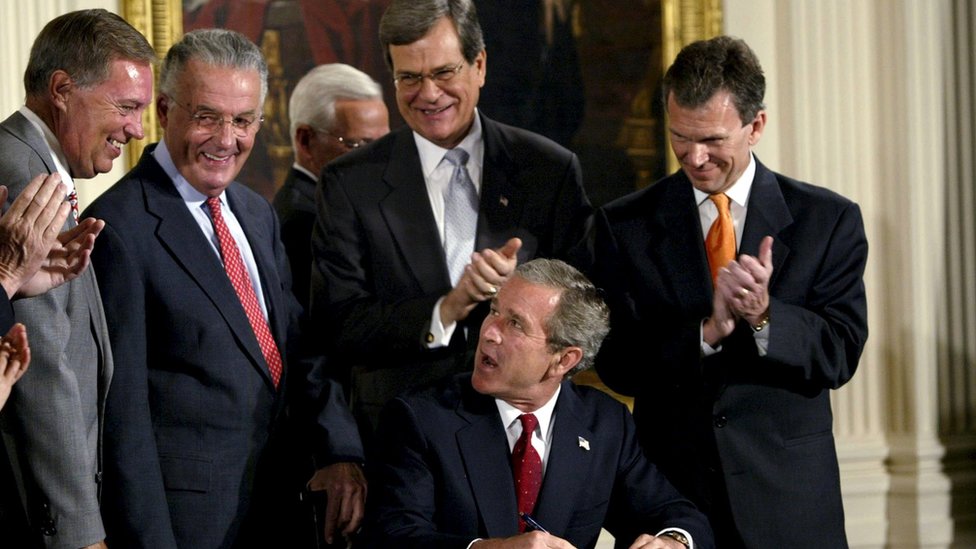 Бывшему президенту США Джорджу Бушу аплодируют после подписания законопроекта, который увеличивает штрафы за мошенничество в бухгалтерском учете и предоставляет новые основания для преследования корпоративной коррупции в Восточном зале Белого дома, на этой фотографии из архива 30 июля 2002 года.