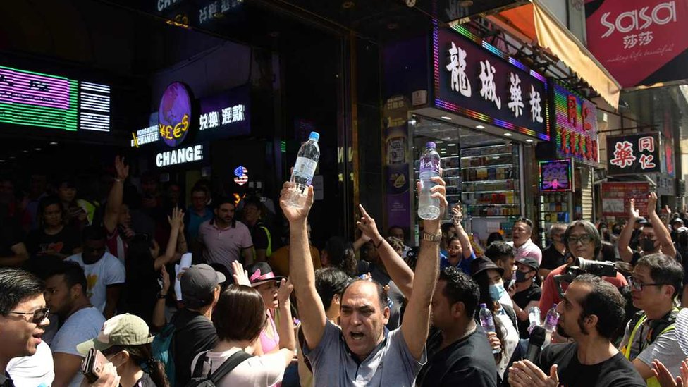 少數族群市民周日的遊行期間，在重慶大廈大門向參加遊行途經的人士派發瓶裝水。