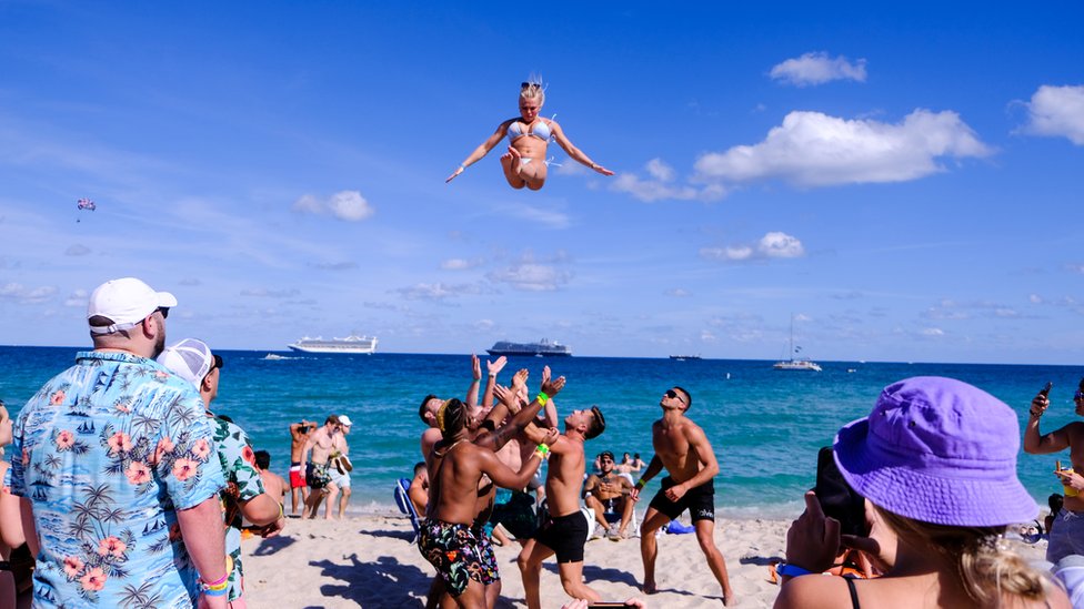 Un grupo de jóvenes lanza por los aires a una chica en Miami Beach