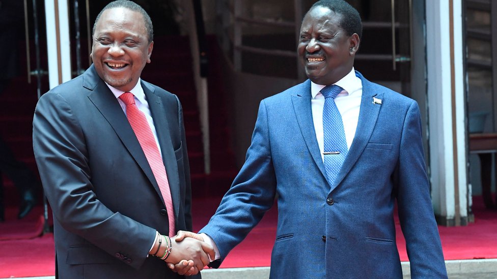 Президент Ухуру Кеньятта (слева) и Раила Одинга (справа) обмениваются рукопожатием в феврале 2018 года