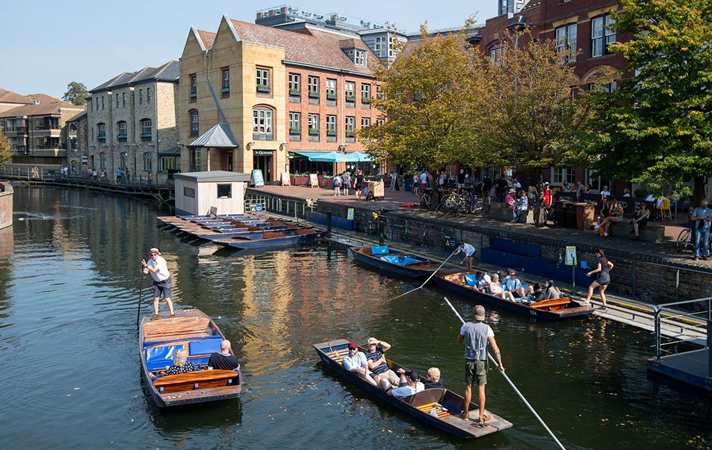 People enjoying the autumn sunshine as they punt along the River Cam