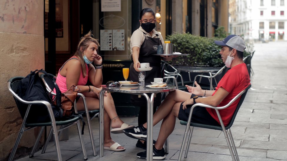 Duas pessoas tomam café da manhã em bar de Madrid, na Espanha