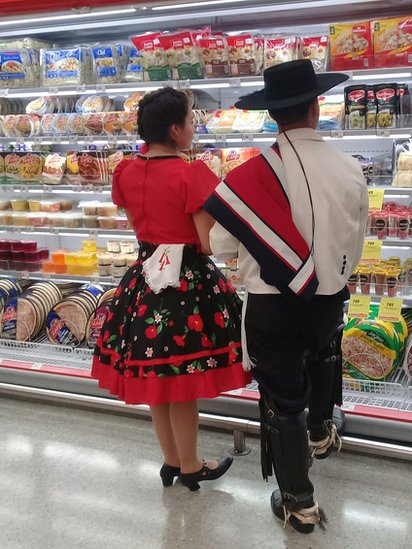 Pareja en un supermercado con traje regional en Chile.