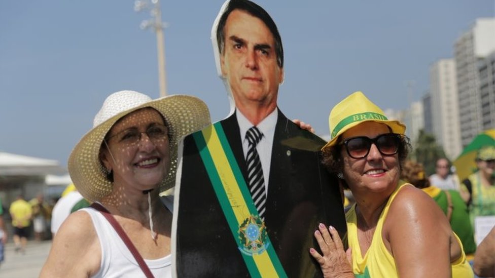 Демонстранты позируют рядом с вырезанным из картона изображением президента Бразилии Жаира Болсонару, когда они присутствуют на акции протеста против коррупции и в пользу расследования коррупции «Автомойка» в Рио-де-Жанейро, Бразилия, 7 апреля 2019 г.