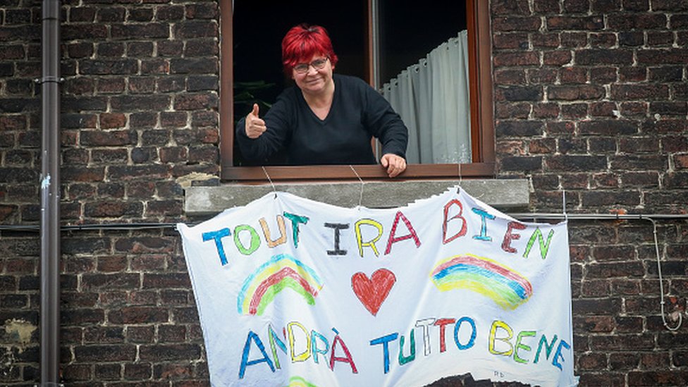 Una mujer italiana con un mensaje de esperanza en su ventana.