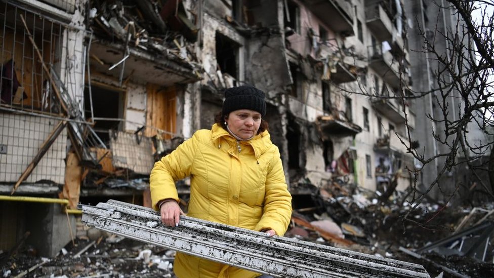Mujer carga escombros en Kiev.