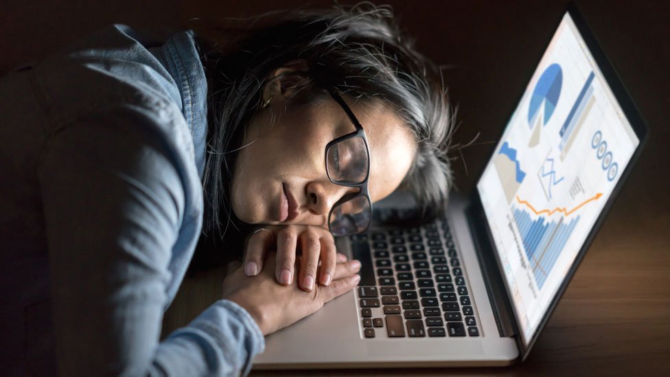 Una mujer duerme sobre un teclado de pantalla.
