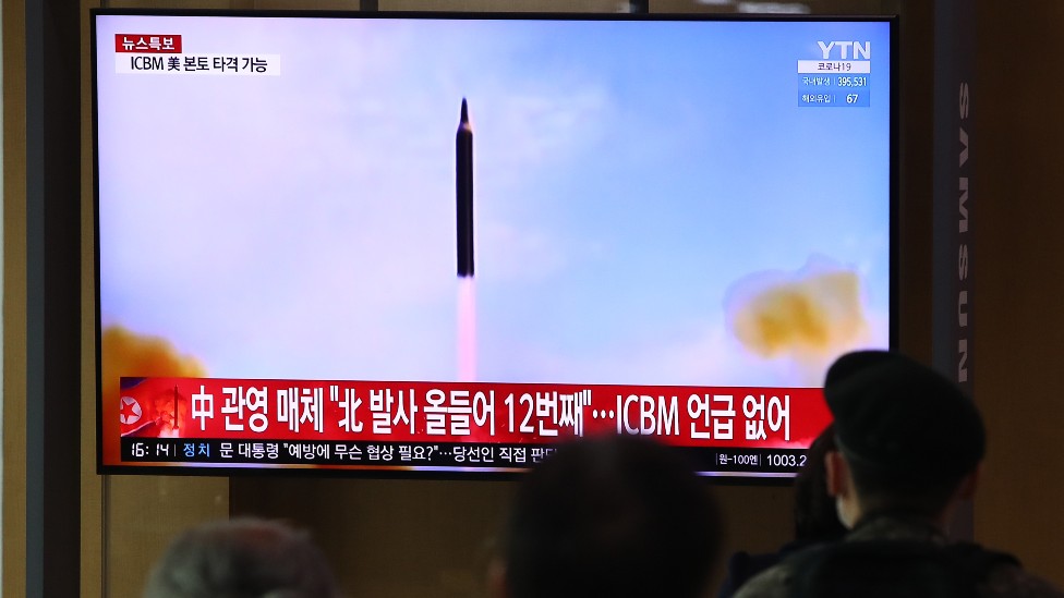 Gente en la estación de trenes de la capital de Corea del Norte mirando el lanzamiento del misil