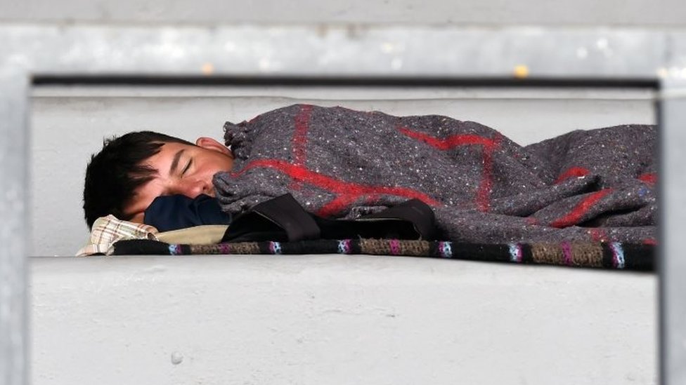 Un niño migrante duerme en el estadio en Ciudad de México