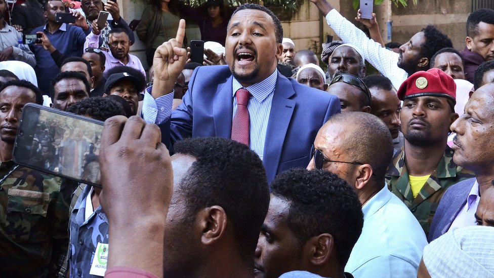 Джавар Мохаммед (C), член этнической группы оромо, который публично критиковал Абия, обращается к сторонникам, которые собрались у его дома в столице Эфиопии Аддис-Абебе после того, как он обвинил силы безопасности в попытке организовать нападение на него. 24 октября 2019 г.