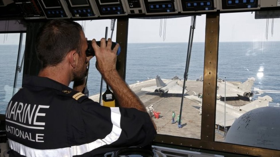 Лейтенант наблюдает за движением истребителей Rafale с командного пункта на борту французского «Шарля де Голля»