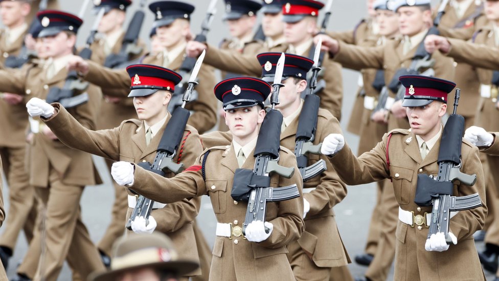 Младшие солдаты в шеренге выступают на параде с винтовками
