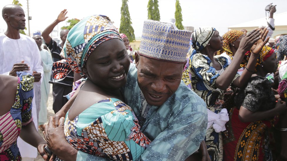 Los padres viajaron un día y una noche completas en autobús para llegar desde Chibok hasta Abuja. Un hombre abraza a una chica joven.