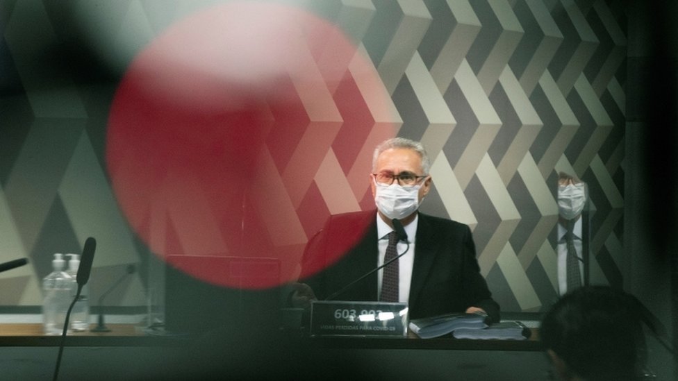 Renan Calheiros sentado de máscara diante de mesa na CPI