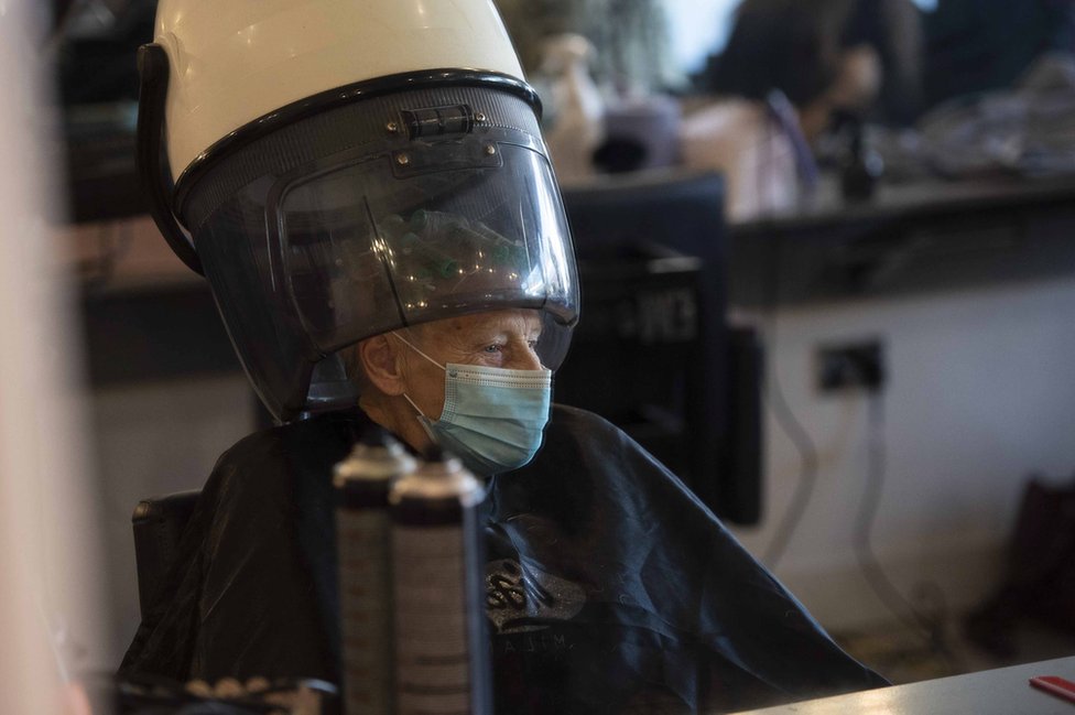 Пожилая женщина в маске в парикмахерской