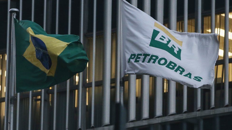 Бразильский флаг и флаг Petrobras развеваются перед штаб-квартирой Petrobras в Рио-де-Жанейро 13 апреля 2016 г.