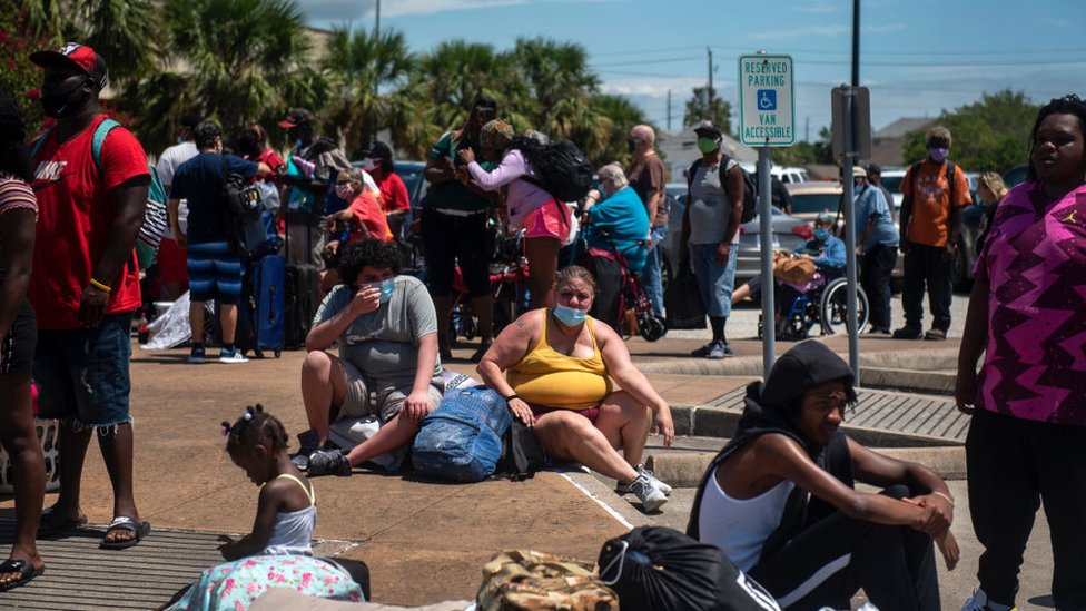 Брайан Нельсон Понсе, 15 лет, и Фрэнсис Нельсон, 46, ждут, чтобы сесть в автобус, пока жители эвакуируются перед ураганом Лора в Общественном центре острова 25 августа 2020 года в Галвестоне, штат Техас
