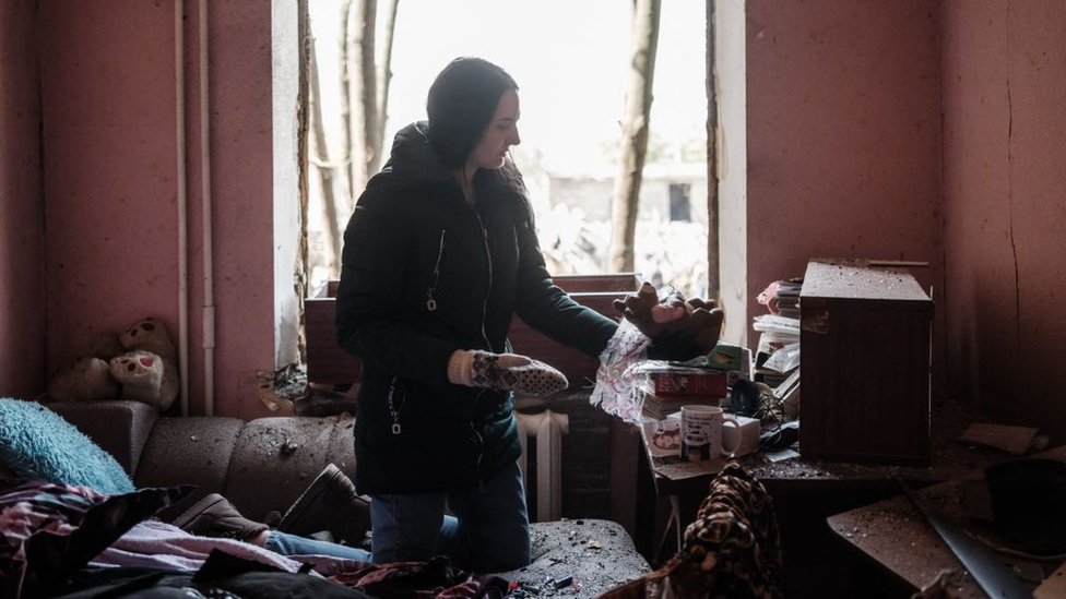 Mujer junta lo que puede en su apartamento destruido por una explosión en Kramatorsk.