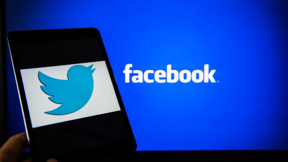Logo de Twitter delante de un fondo con el logo de Facebook
