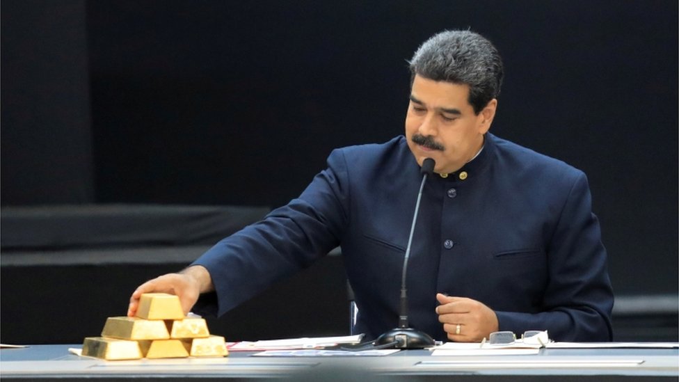 Президент Венесуэлы Николас Мадуро касается золотого слитка во время выступления во время встречи с министрами, отвечающими за экономический сектор, во дворце Мирафлорес в Каракасе, Венесуэла, 22 марта 2018 г.
