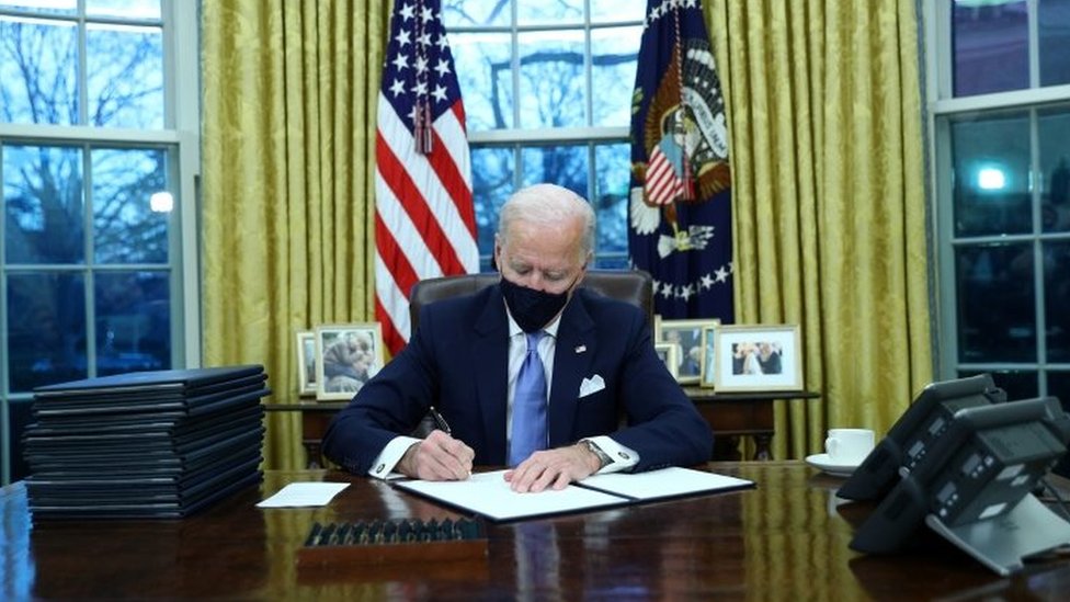 Biden desde la Oficina Oval firmando órdenes ejecutivas.