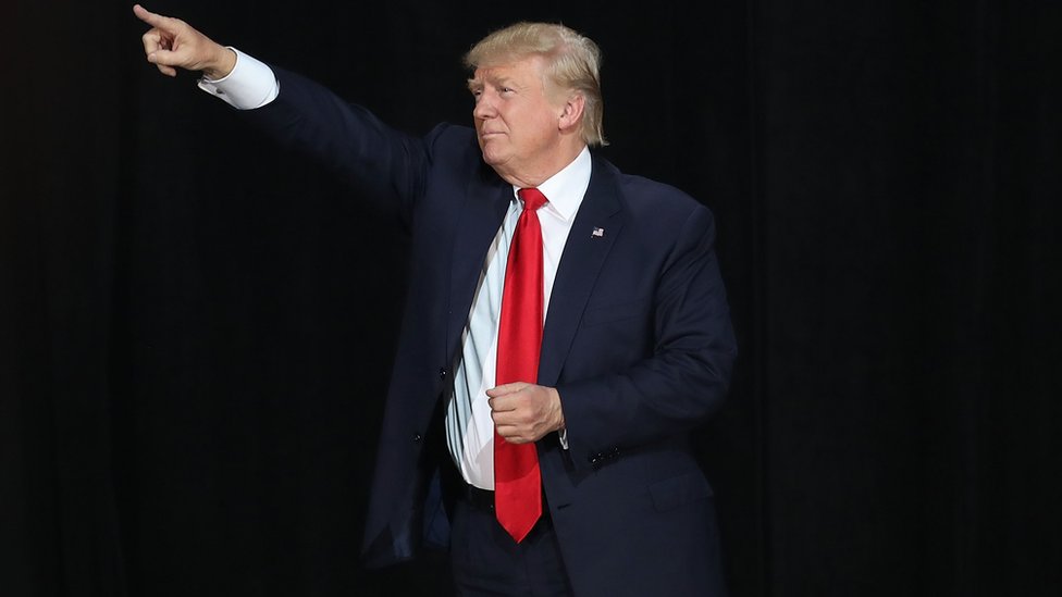 Дональд Трамп - выступает перед аудиторией с поднятой рукой