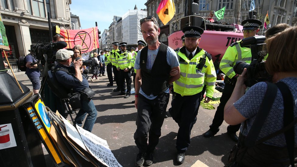 Полицейский уводит протестующего с улицы Оксфорд-Серкус