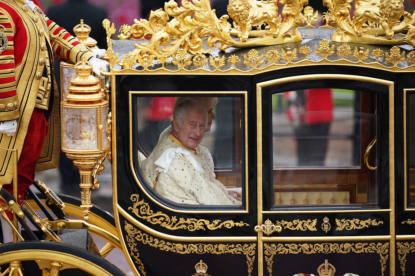 King Charles smiles as the carriage leaves Buckingham Palace and heads down The Mall