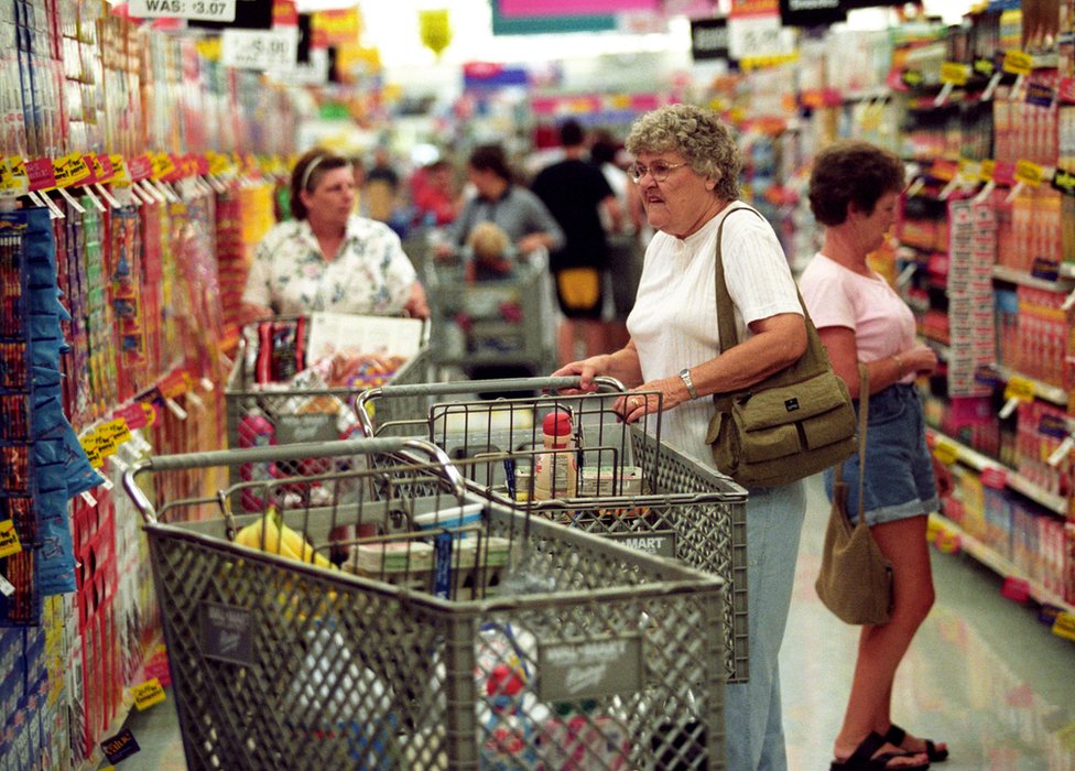 Покупатели делают покупки во время торжественного открытия супермаркета Wal-Mart 14 августа 2002 года в Афинах, штат Огайо.