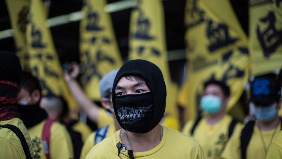 Член группы Civic Passion наблюдает за тем, как он и другие участники участвуют в акции протеста против параллельной торговли в районе Юэнь Лонг в Гонконге 1 марта 2015 г.