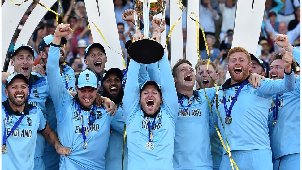 Капитан Англии Эоин Морган поднимает трофей чемпионата мира, когда игроки сборной Англии празднуют победу после чемпионата мира по крикету 2019 года