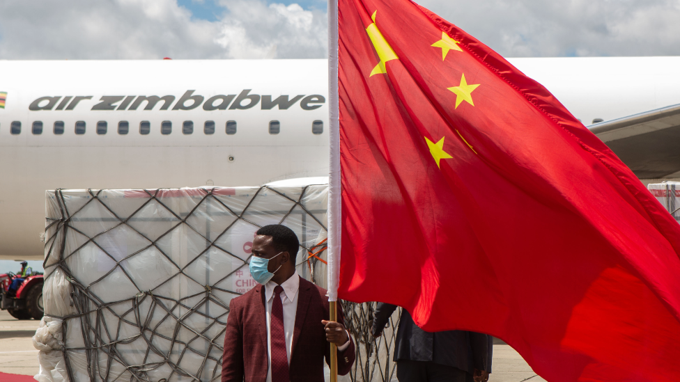 짐바브웨 공항에서 한 남성이 중국 국기를 들고 있다