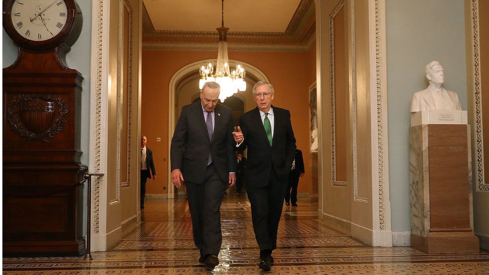 Лидер сенатского меньшинства Чарльз Шумер (штат Нью-Йорк) (слева) и лидер сенатского большинства Митч МакКоннелл (республика Кентукки) идут бок о бок в палату Сената Капитолия США 7 февраля 2018 г.