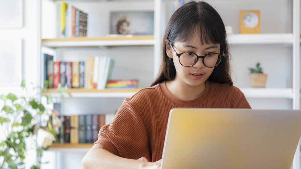 A student sat at her laptop