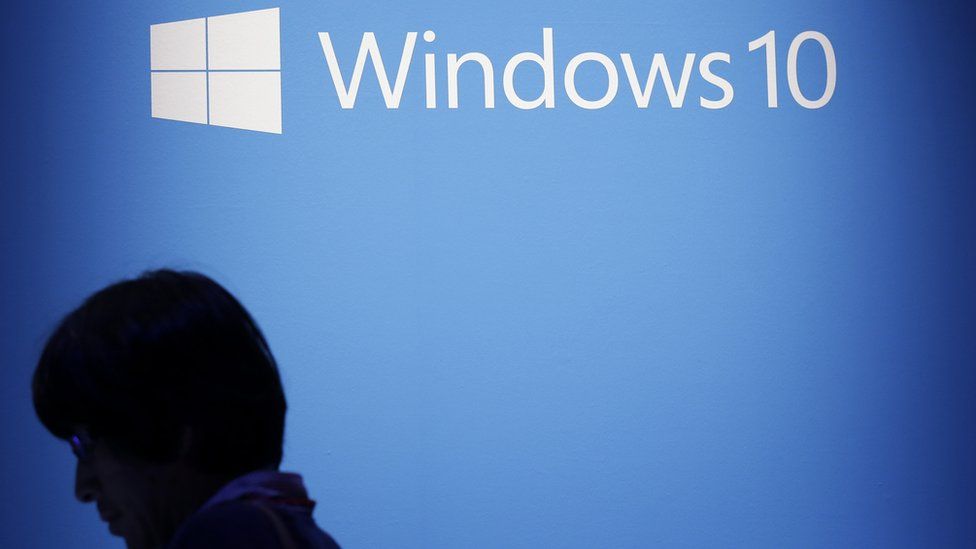 Logo de Windows 10 en una pantalla en la que aparece un señor.