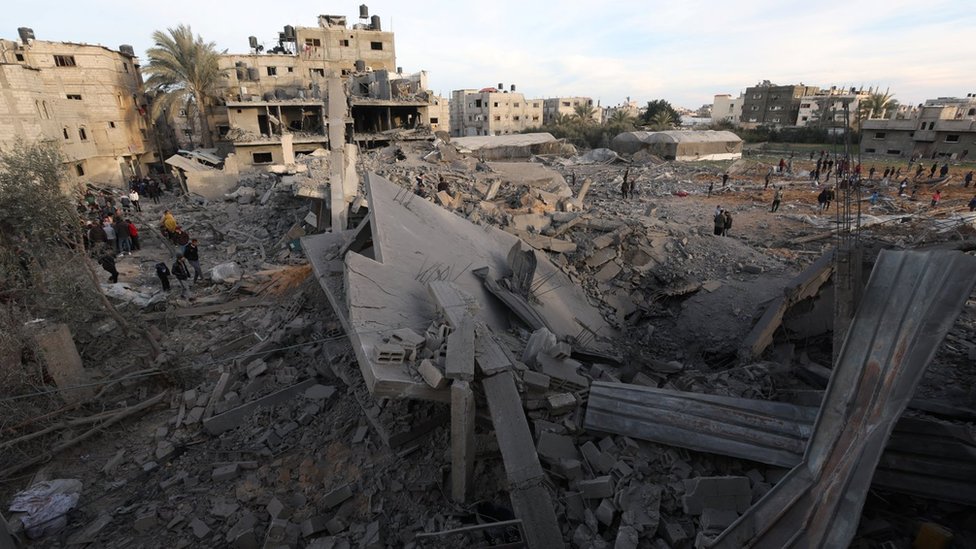 Palestinian inspect the rubble of destroyed residential buildings in Rafah, in the southern Gaza Strip, following an Israeli operation to rescue hostages (12 February 2024)