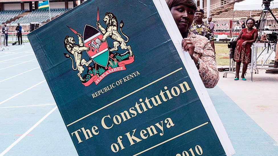 Una mujer lleva una réplica gigante de la constitución de Kenia antes de la ceremonia de dedicación presidencial en Nairobi el 17 de noviembre de 2017.