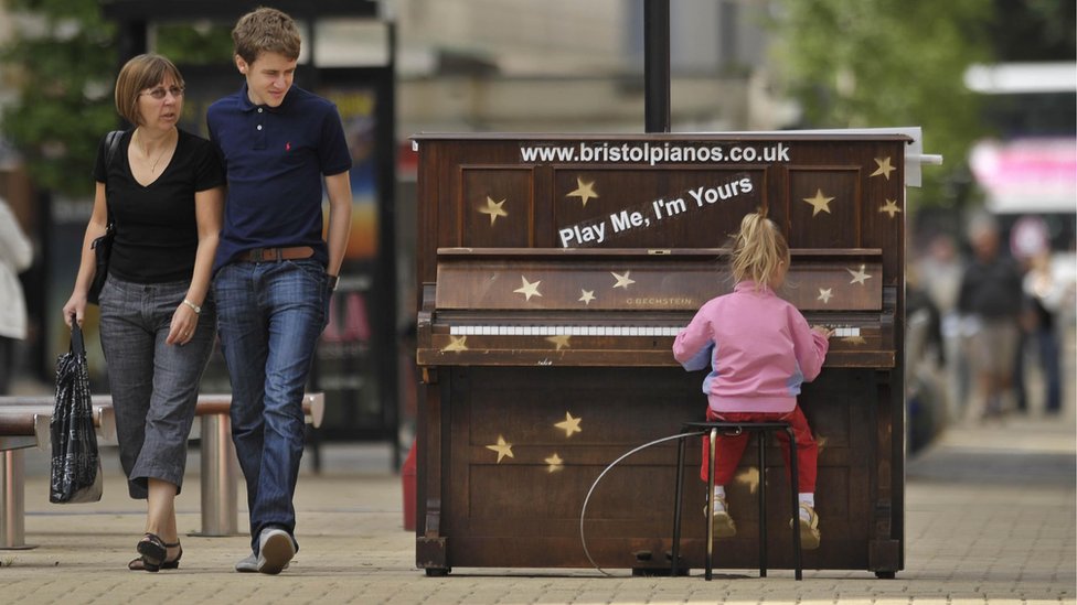 Девушка играет на пианино, установленном в Бристольском Бродмиде в 2009 году