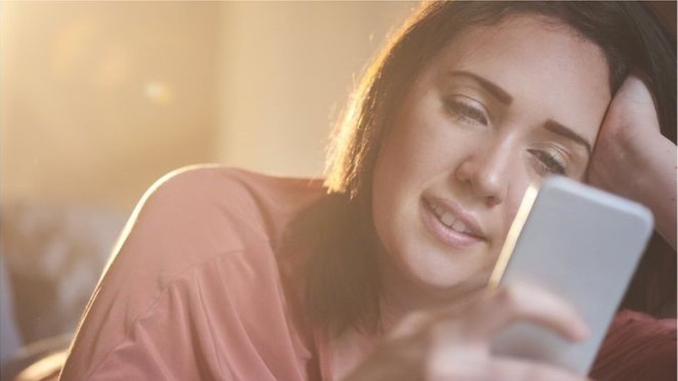 فتاة تتصفح هاتفها النقّال