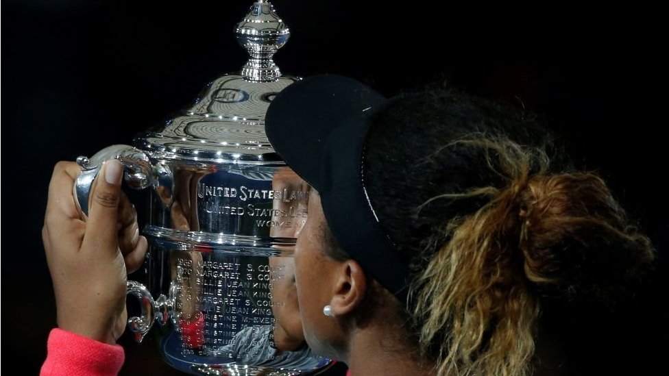 Naomi Osaka kisses the US Open trophy in 2018