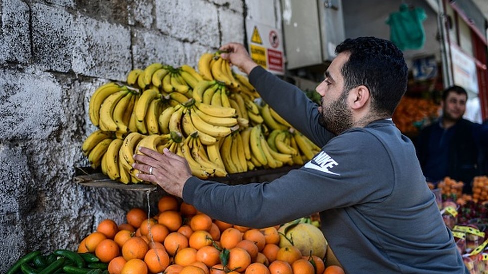 A Syrian greengrocer displays bananas on a stall of his shop in Gaziantep