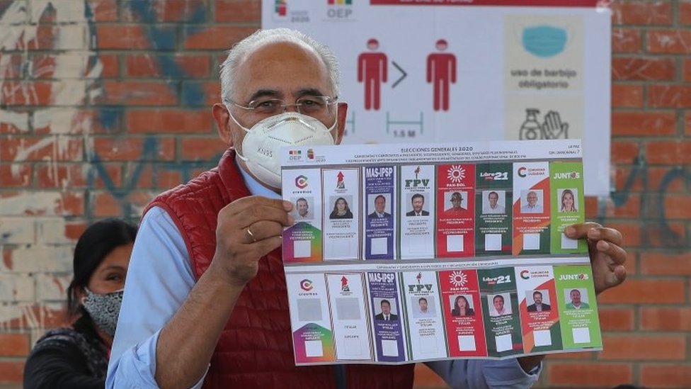 Presidential candidate Carlos Mesa shows the electoral ballot when casting his vote in a precinct in the city of La Paz, Bolivia, 18 October 2020.