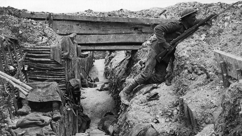 Британский солдат смотрит на линию фронта из окопа
