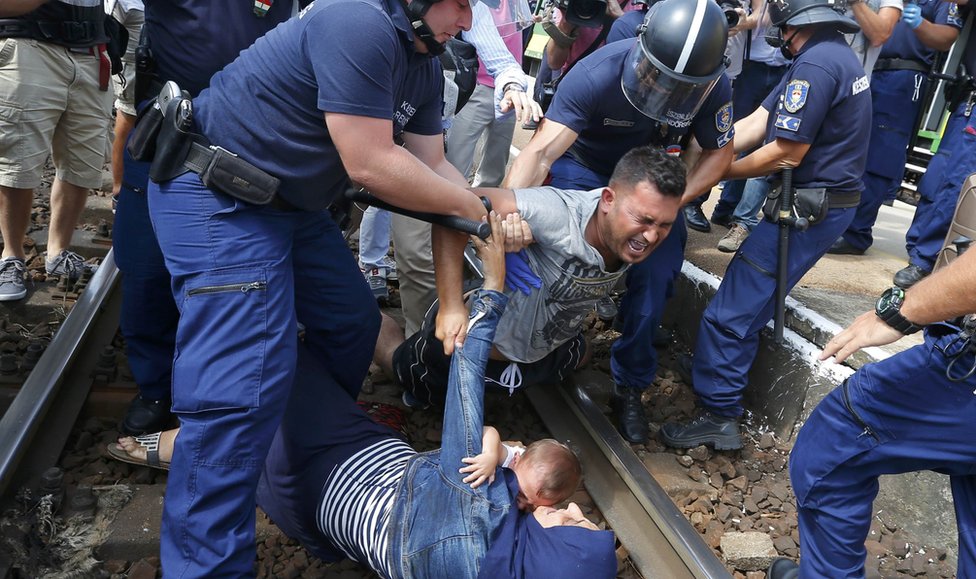Mađarski policajac hapsi migranta na pruzi, Mađarska, septembar 2015. godine