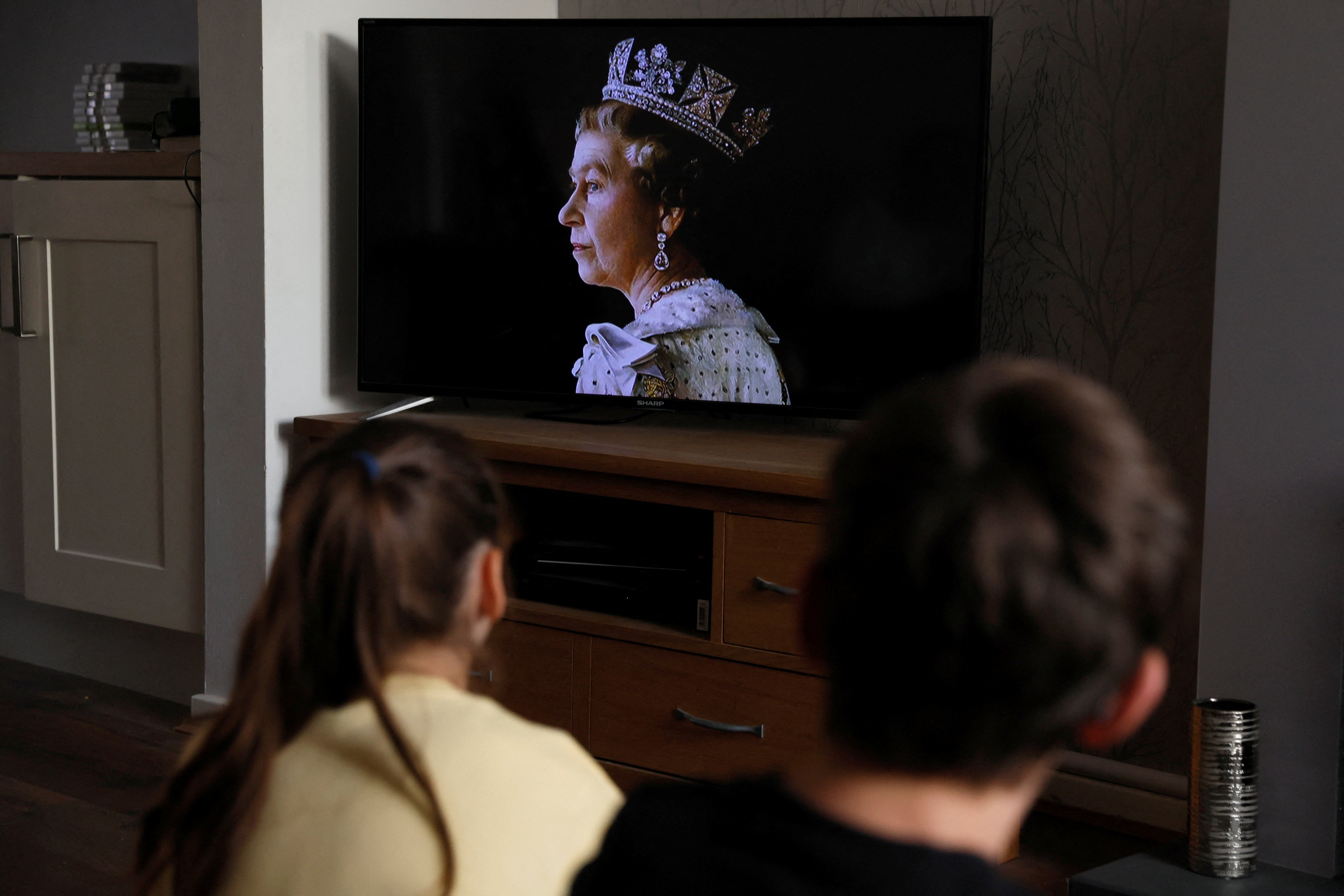Children watch TV as it is announced that Queen Elizabeth, Britain's longest-reigning monarch and the nation's figurehead for seven decades, died aged 96