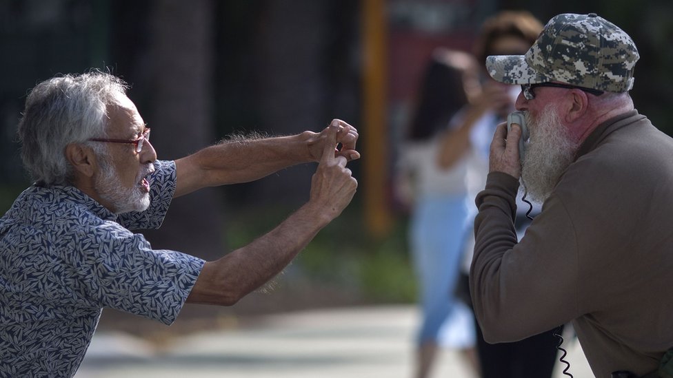 Dos hombres se enfrentan a las afueras de un mitin de Barack Obama en Anaheim, California, en septiembre de 2018