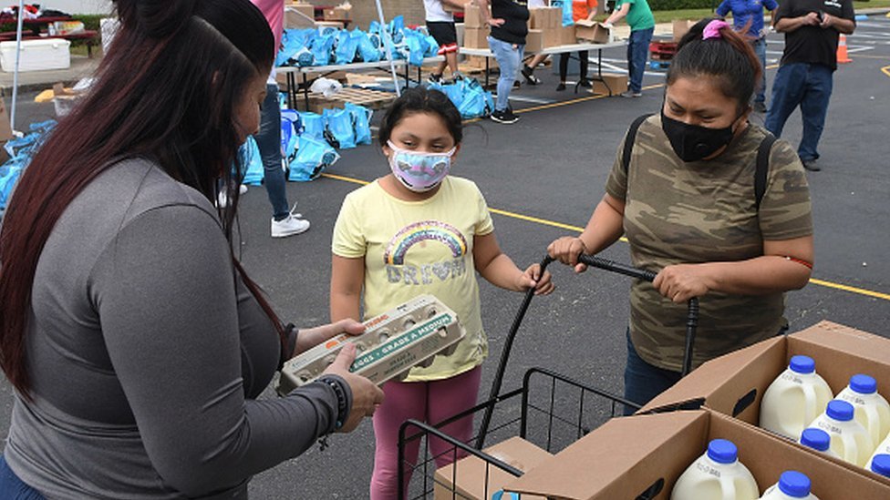 A woman and her daughter receive food assistance at a food distribution event in Orlando, Florida, 12 December 2020