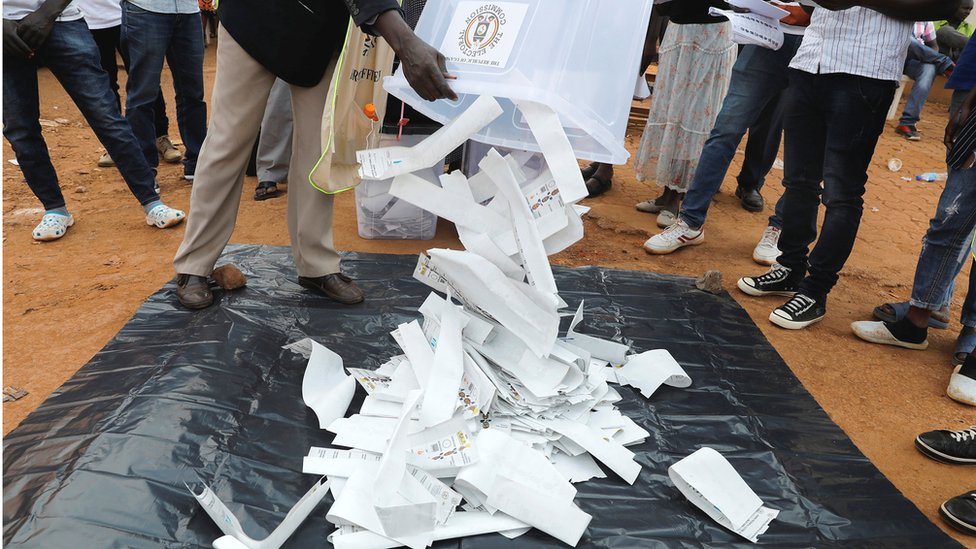 Election officials empty a ballot box to count votes after polling stations closed in elections in Kampala, Uganda - 14 January 2021