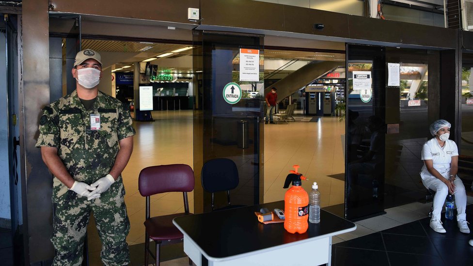 Um militar e uma enfermeira no portão do aeroporto de Luque, perto de Assunção, no Paraguai