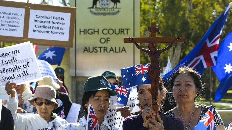 Сторонники Джорджа Пелла несут кресты и знаки перед Высоким судом Австралии во время слушания его апелляции